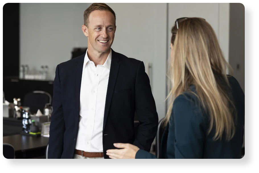 Two business professionals having a friendly conversation in a modern office